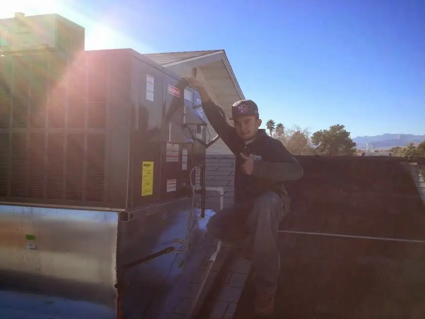 HVAC technician performing HVAC Inspection on a rooftop unit in Hurricane